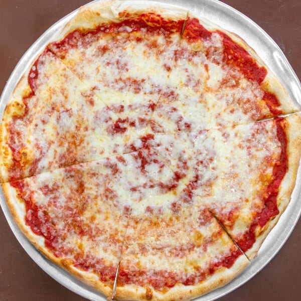 A whole, sliced Carini's cheese pizza with red sauce and melted white cheese on a metal pan.